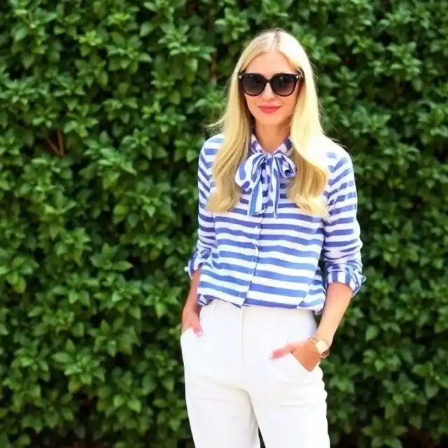 A preppy outfit featuring a collared shirt, tailored blazer, plaid skirt, and polished loafers, exuding a classic and refined aesthetic.